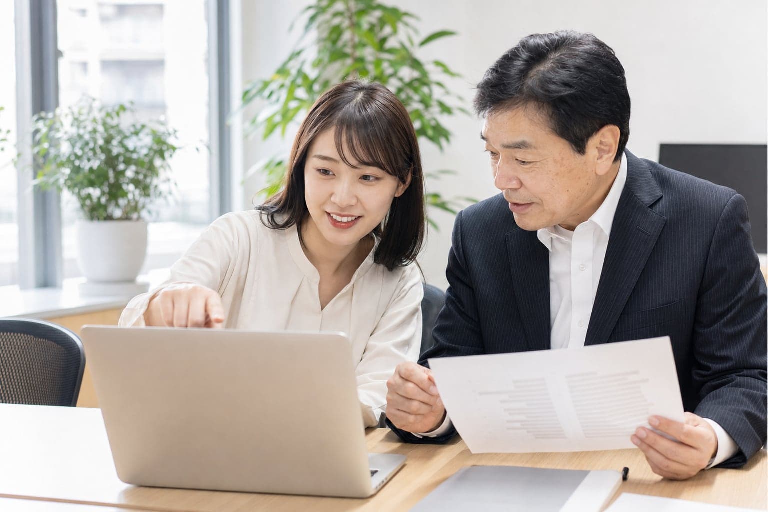 2人で書類とパソコンを見ながら確認している様子